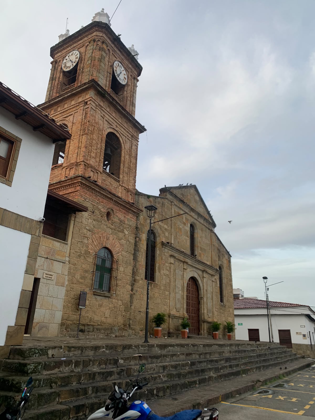 Torre del reloj y muros de piedra de un templo colonial en el centro histórico de El Socorro.